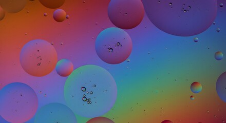 Oil and water vibrant spheres in rainbow hues with smaller bubbles trapped inside