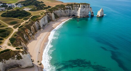 Explore the beauty of aerial view of etretat beach in france showcasing crystal clear blue-green water and sandy shoreline, with waves crashing along the coastline.