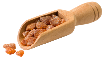 Crushed amber in the wooden scoop, isolated on white background.