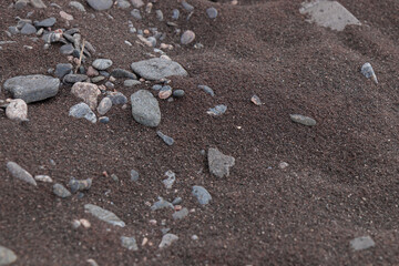 Close-up view of the dark iron sand on the unique beach of Jussaro Island, Finland. The shoreline was shaped by iron ore mining, leaving a striking trace of the industrial past