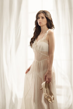 Woman In Lingerie Holding Shoes