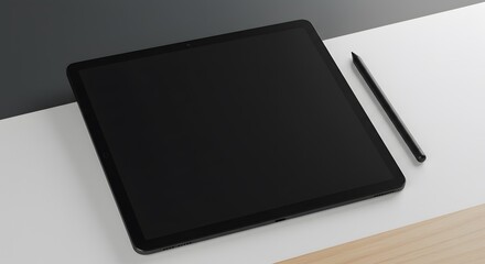 Black tablet and pen rest on a dualtone surface white and gray to the left and white and tan on the right