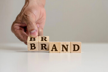 Hand building the word brand with wooden letter cubes © Naifa