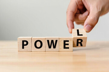 Hand placing wooden blocks to spell the word power