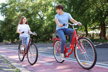Obraz premium Teenage girl and boy riding bicycles on city street