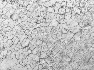 Cracked gray concrete wall texture. Aged cement wall with cracks. Closeup of rough cement surface with natural cracks. Wall fragment with cracks and scratches.