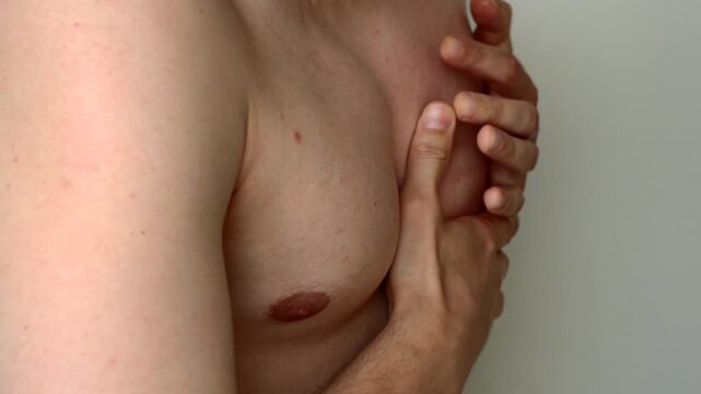 Naked man feels pain in his heart and holds his hand to his chest.
Heart attack and stroke in a guy.
Sharp and unexpected pain in the chest and heart