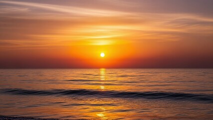 Fototapeta premium Sunset over calm ocean waters with vibrant colors reflecting on the surface.