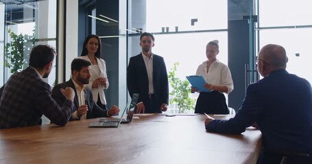 Business professionals in formal attire are gathered around a conference table, discussing strategy and making decisions together in a modern office setting. Teamwork in business setting. - Powered by Adobe