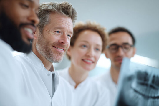 Dedicated team of doctors in lab coats studying a medical scan. Concept for medical teamwork, diagnostics, and healthcare excellence. Ideal for medical websites or publications.