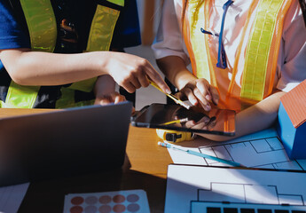 Closeup of team of industrial engineers meeting analyze machinery blueprints consult project on table in manufacturing factory. Working in manufacturing plant or production plant.