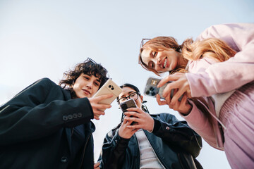 Friends using smartphones on urban street in Seoul from low angle view