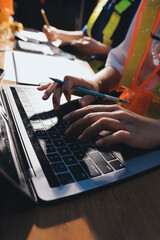 Closeup of team of industrial engineers meeting analyze machinery blueprints consult project on table in manufacturing factory. Working in manufacturing plant or production plant.