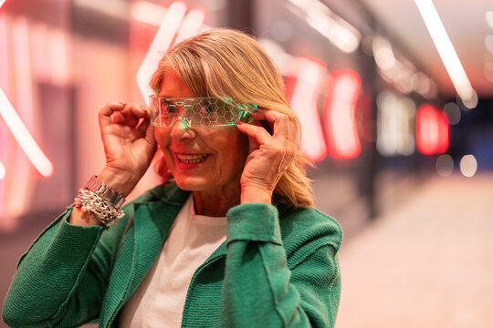 Woman smiling wearing futuristic vr headset with neon lights