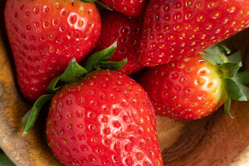 Fresh strawberries with green leaves arranged close up