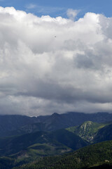Fototapeta premium A helicopter against a cloudy mountain sky