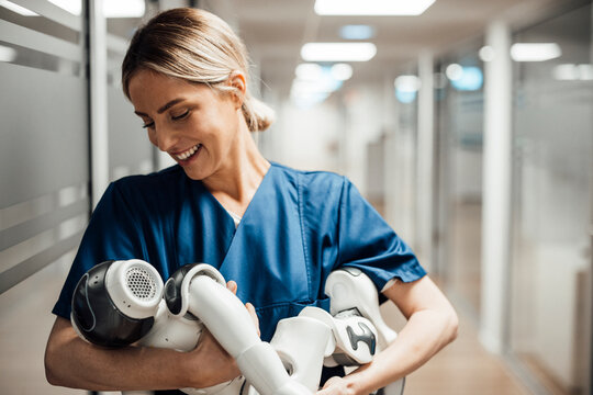 Nurse holding robot baby in hospital corridor symbolizing AI in healthcare