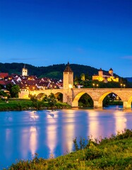 Obraz premium European town at dusk, with bridge over river