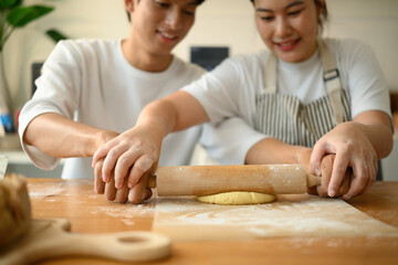 A happy baking moment, Close up of two people roll out fresh dough side by side, preparing homemade cookies