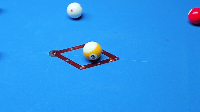 Billiard balls colliding and scattering across blue pool table after break shot with strong motion blur and dynamic movement top view slow motion action