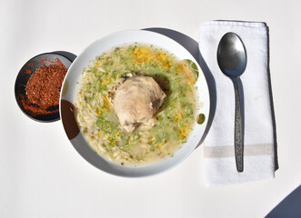 Chicken and Orzo Soup with Herbs isolated on white background, top view