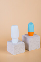 Cosmetic product in tube, bottle, lotion or serum with stylish props on cream background. 