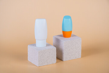 Cosmetic product in tube, bottle, lotion or serum with stylish props on cream background. 