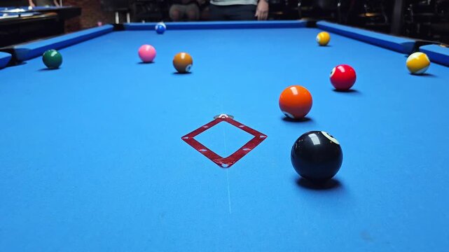 Billiard balls arranged in triangle on blue pool table hit by cue ball during break shot. Pool game and sports recreation video footage. Front view