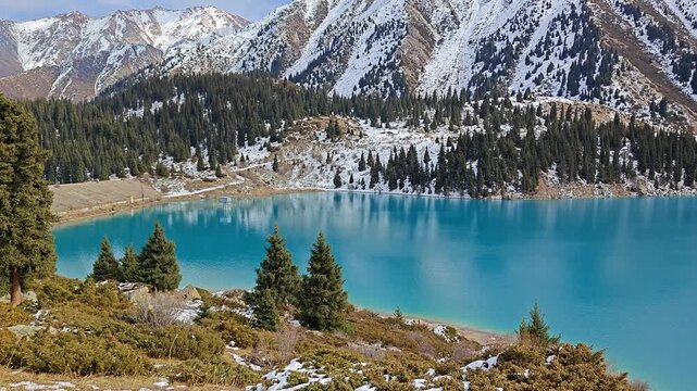 Big Almaty Lake. Scenic mountain lake surrounded by lush greenery and snow-capped peaks