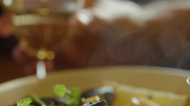Hand Lifting Spoonful of Steaming Seafood Chowder