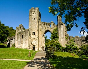 Ancient stone castle ruins, green lawns, pathway