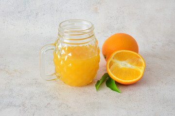 Orange Juice in a Mason Jar decorated with Oranges and green leaves