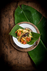 Som Tam , a popular and favourite Thai food dish made of young sliced papaya, chili, tomatoes, palm sugar and dried shrimp , top view.