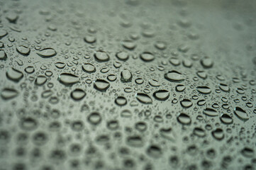 Close-up of raindrops on a window with selective focus. Black and white natural texture for a calm or melancholic mood