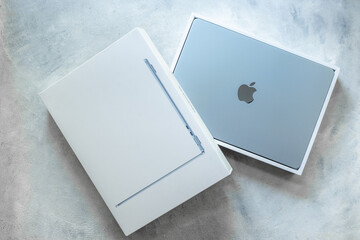 Apple MacBook Air 13 M4 Sky Blue color 2025. Laptop in a box on gray desk top. Unpacking, top view....