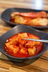 Spicy Korean Radish Kimchi in a Black Bowl