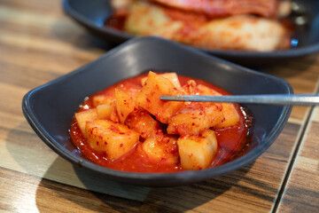 Spicy Korean Radish Kimchi in a Black Bowl