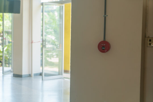 Red Alarm Bell on Wall Near Open Door