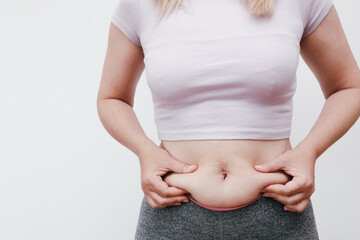 Closeup hand holding abdominal surface woman fat, healthy care and beauty concept. Healthcare and woman diet lifestyle concept