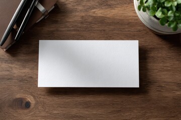 Blank white rectangular card mockup on a rustic wooden desk with office supplies.