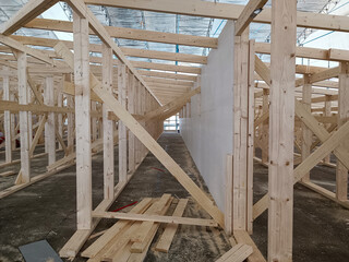 Obraz premium Construction work on the roof frame. Wooden structure made of timber. Carpenters and joiners products