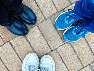 Different footwear types displayed on a brick paved surface during a casual gathering, showcasing individuality
