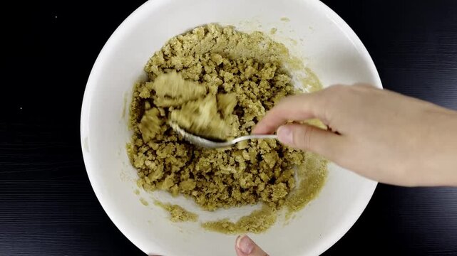 Mixing cookie dough with chocolate chips using a spoon in a white bowl, perfect for recipe videos, food blogs, homemade dessert content, and baking tutorials