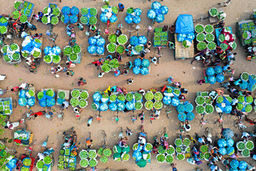 Kansat, Bangladesh - 15 June 2019: Aerial view of a bustling marketplace near Sona Masjid Road, a vibrant tapestry of green produce contrasting with the warm earth tones.