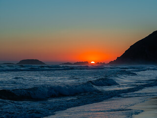 Obraz premium Sunset over the coast of Zarautz with gentle waves and a serene landscape captured during twilight hours