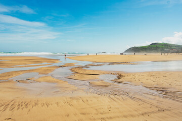 Zarautz beach view with soft sands, calm waves, and people enjoying a sunny day