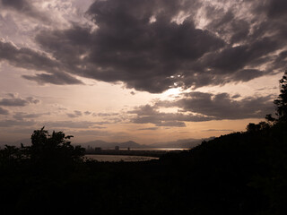 Fototapeta premium Sunset Over Mountains and Industrial Coastline with Dramatic Clouds