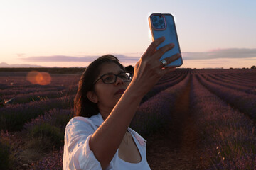 A woman is taking a picture of herself with a cell phone