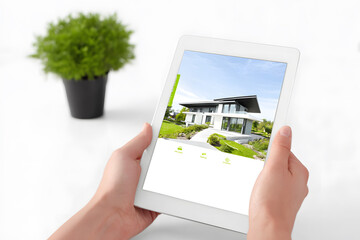 Hands holding tablet showing modern house exterior, representing real estate search and property technology.