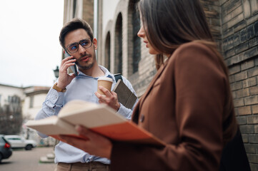 University students studying and talking on phone outdoors